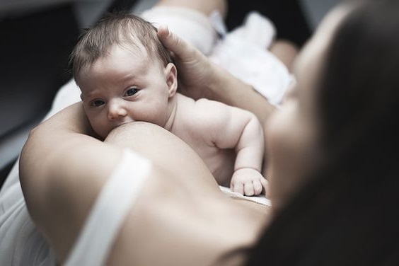 Новорожденный ребенок ест грудное молоко